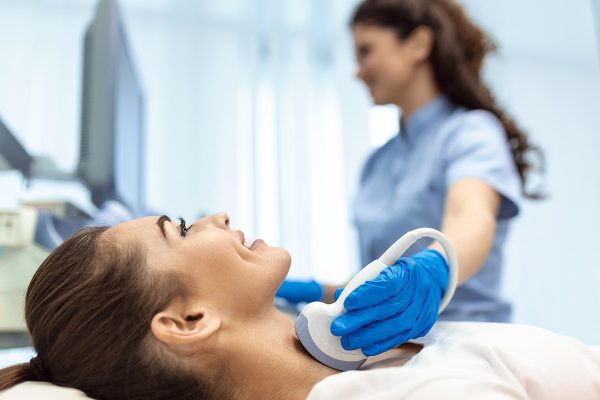 Woman patient receives thyroid diagnostics. Treatment of thyrotoxicosis, and hypothyroidism. Ultrasound diagnostics of the endocrine system and thyroid